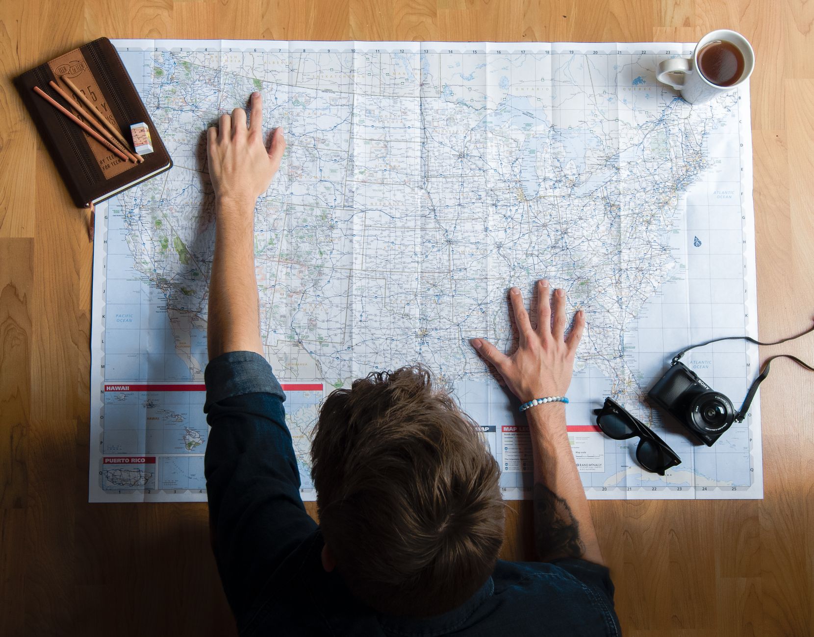 Ministry leader sitting quietly at a table with a map and coffee, planning a restorative trip