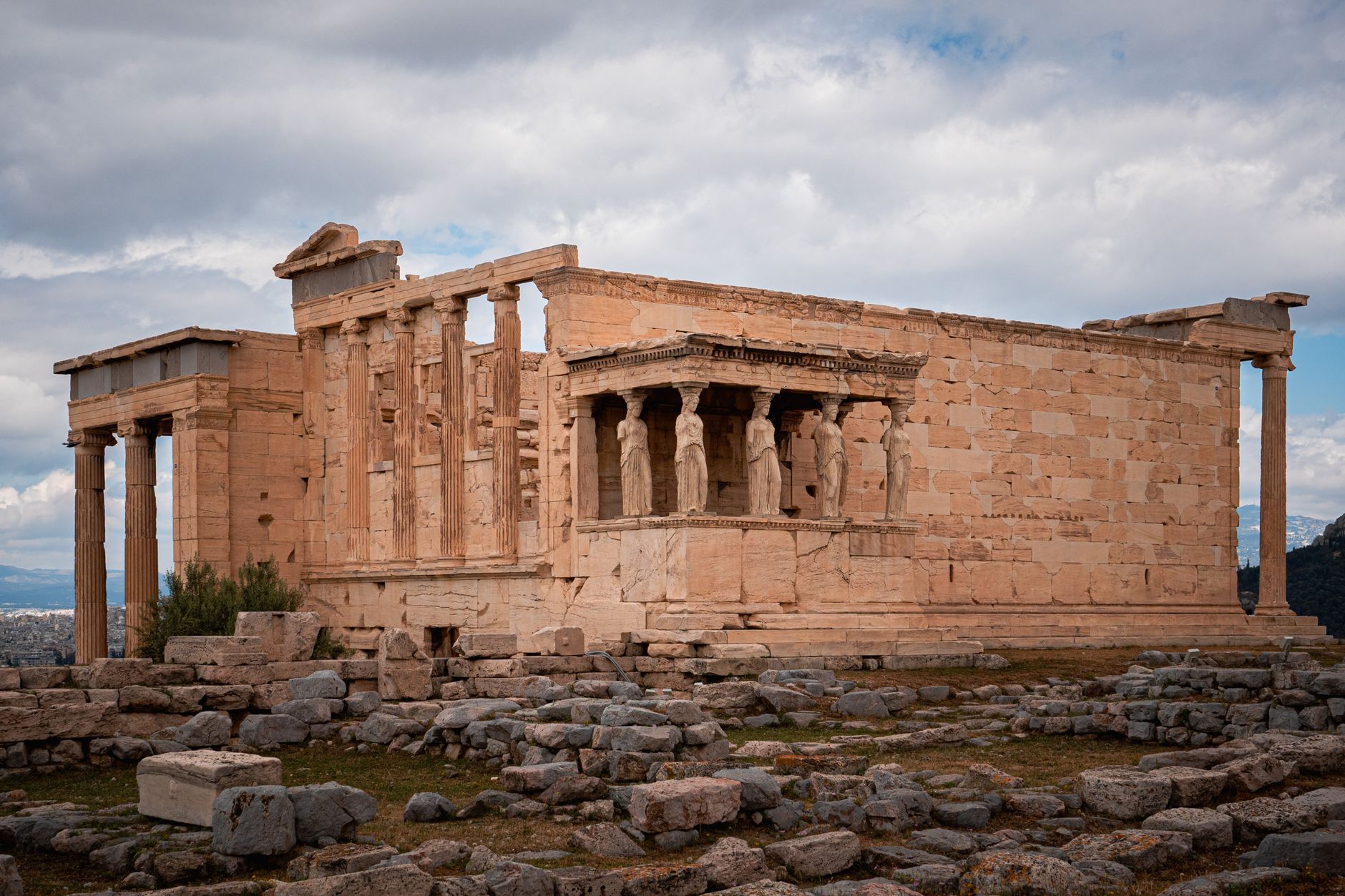 The Erechtheion on the Acropolis, its caryatid porch above scattered stone ruins