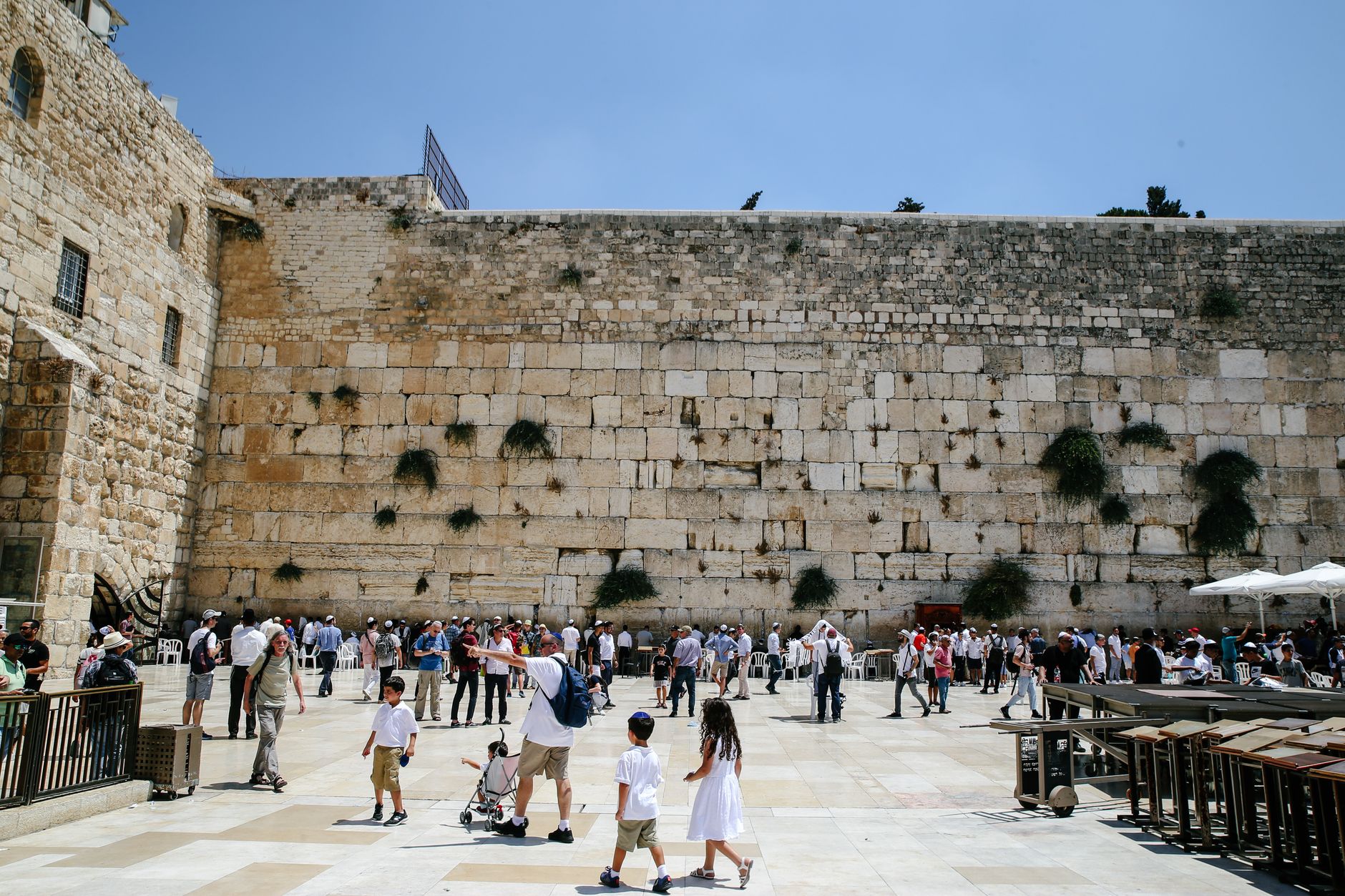 Crowds gathered in the plaza before the great stone courses of the Western Wall