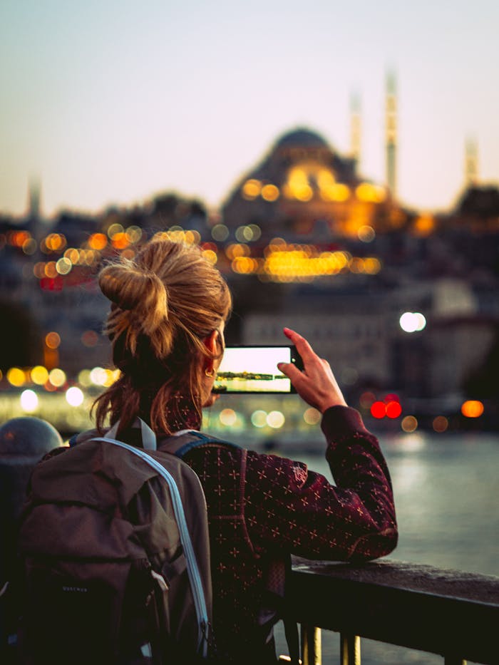 hero-img-02 A traveler captures a ministry travel memory, photographing a mosque in Istanbul with her smartphone.