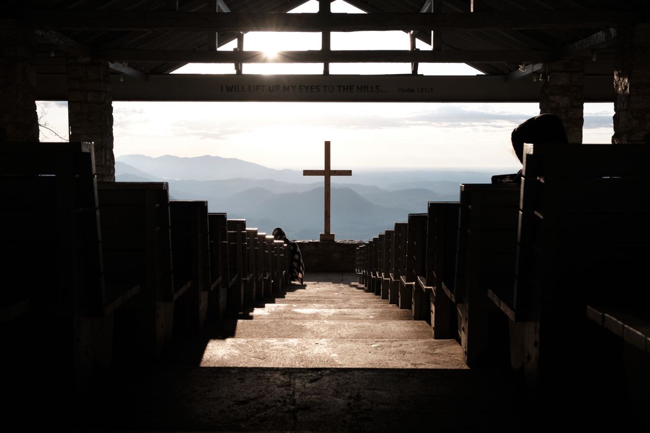 services-01 A serene church interior with a cross and mountain view at sunset, the kind of renewal ministry travel offers pastors.